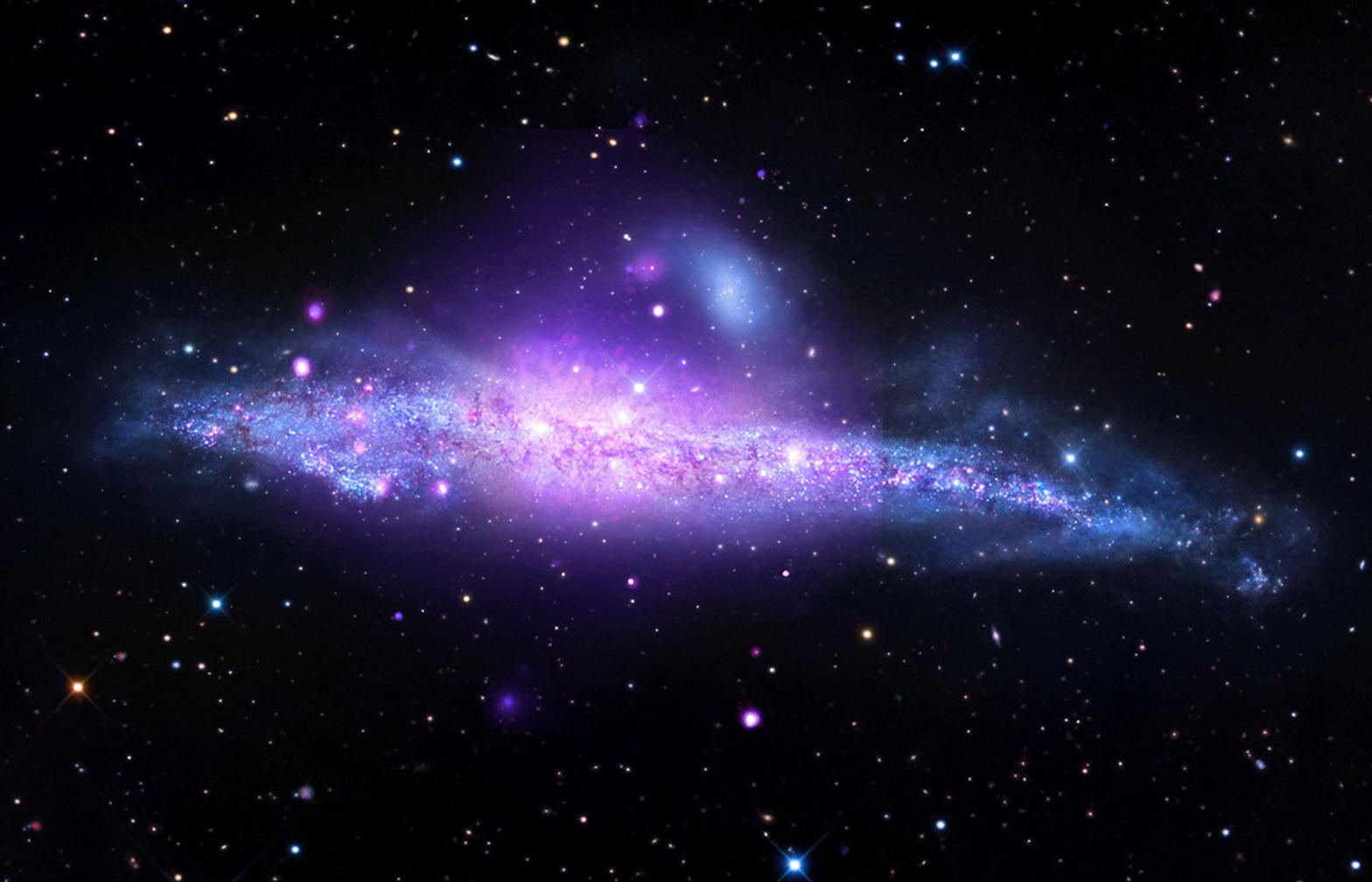The Andromeda galaxy as a purple and blue disk of stars and X-ray light against black space.